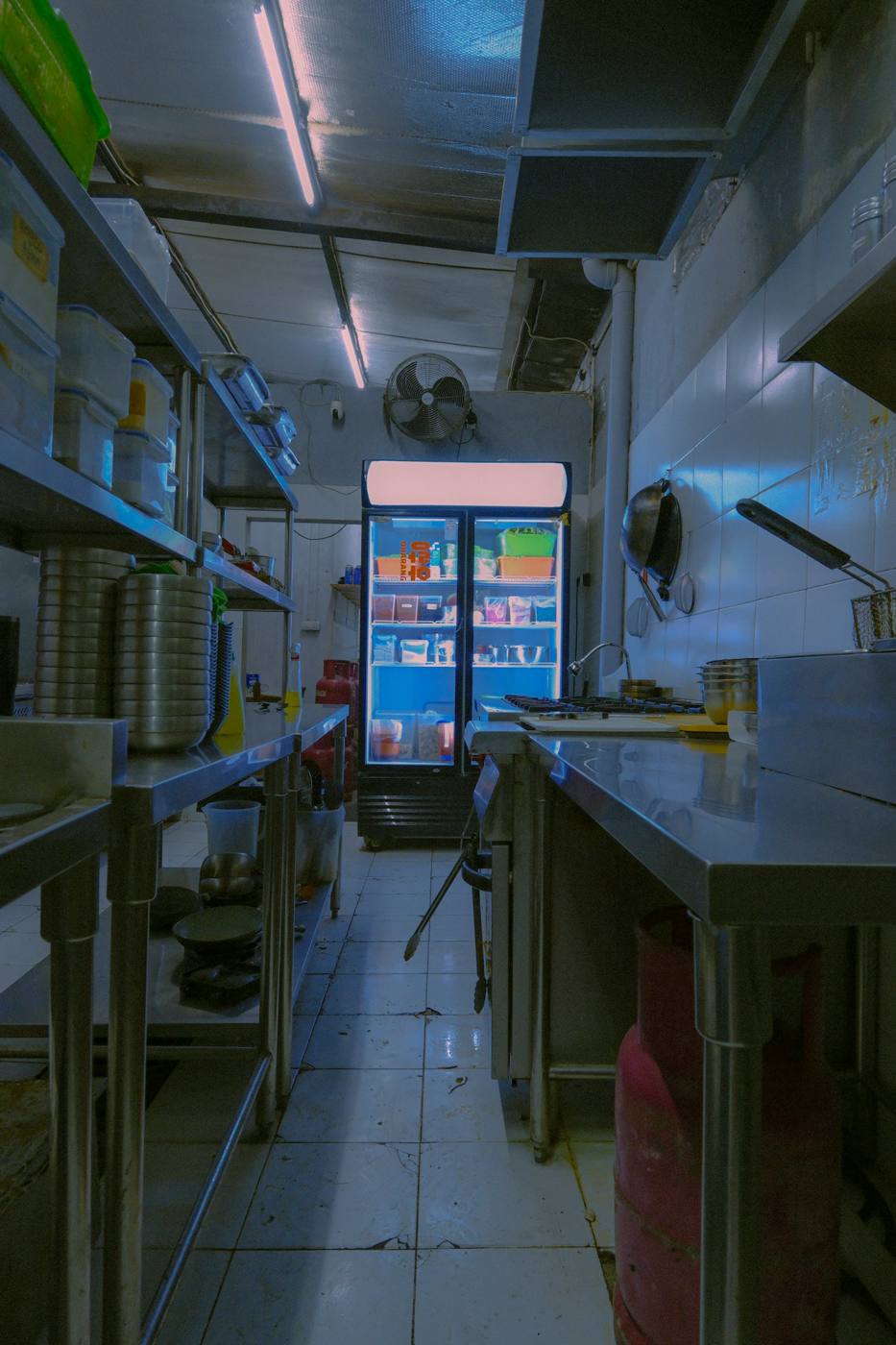 Lit commercial refrigerator in a stainless-steel kitchen